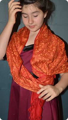 Liana is wearing a sumptuous shawl embroidered in orange and red on ultra-fine wool by the master artisans at Local Womens Handicrafts in Kathmandu, Nepal